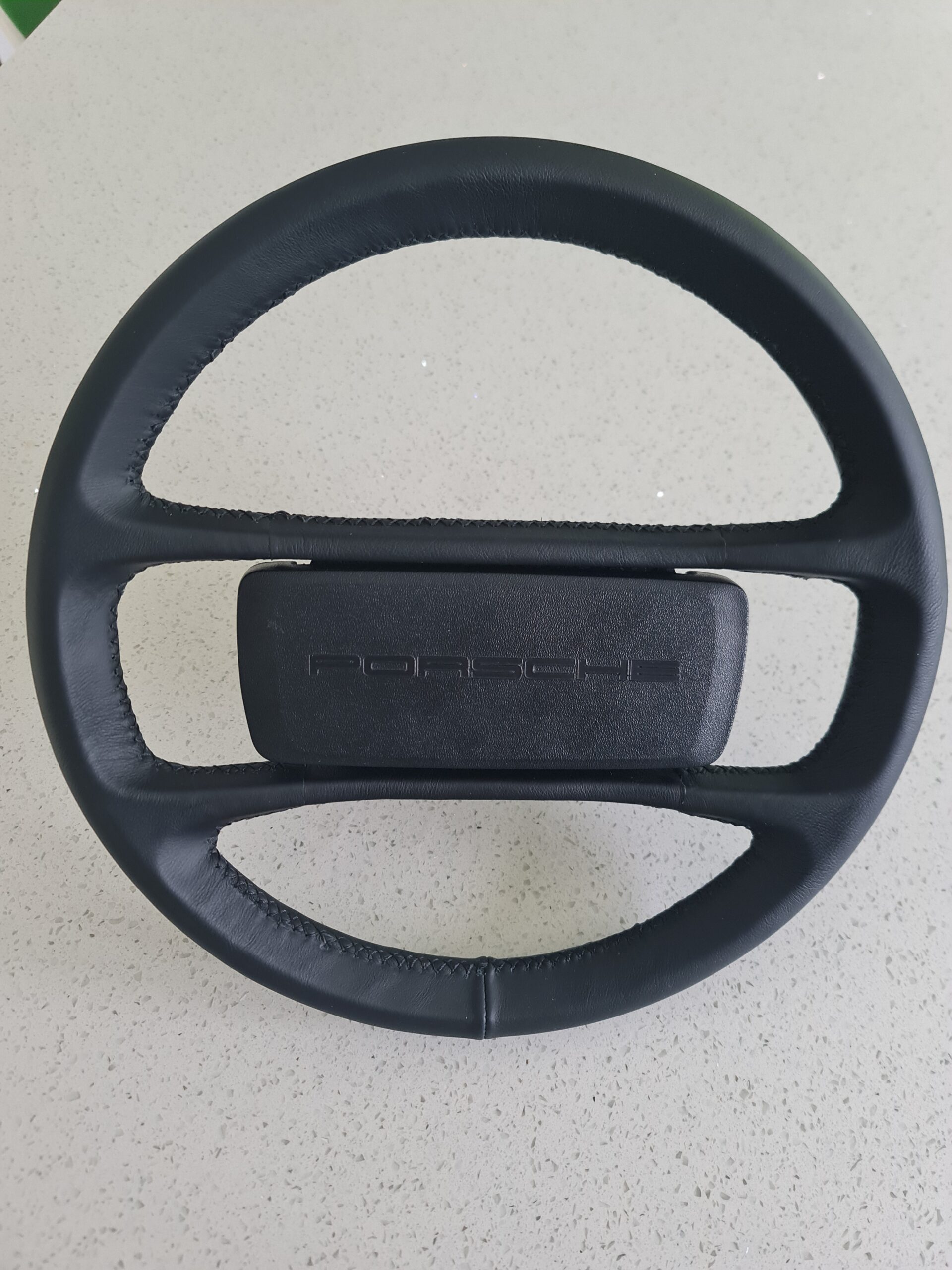 Classic Porsche steering wheel professionally restored with OEM-style leather and stitching