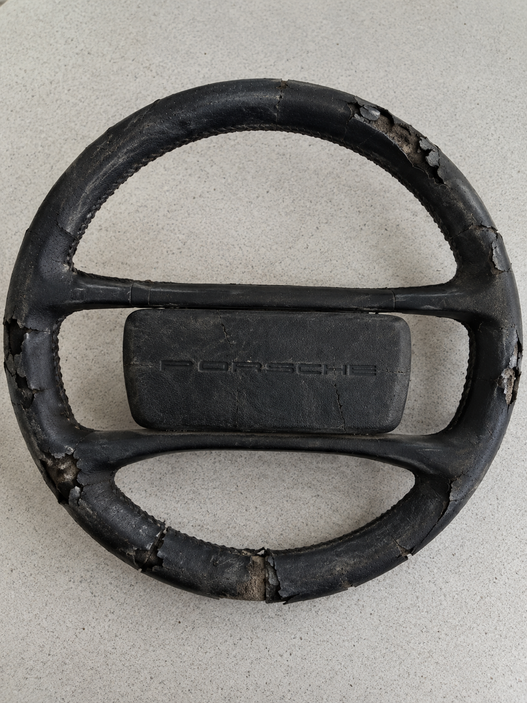 orn and faded leather Porsche steering wheel before restoration.